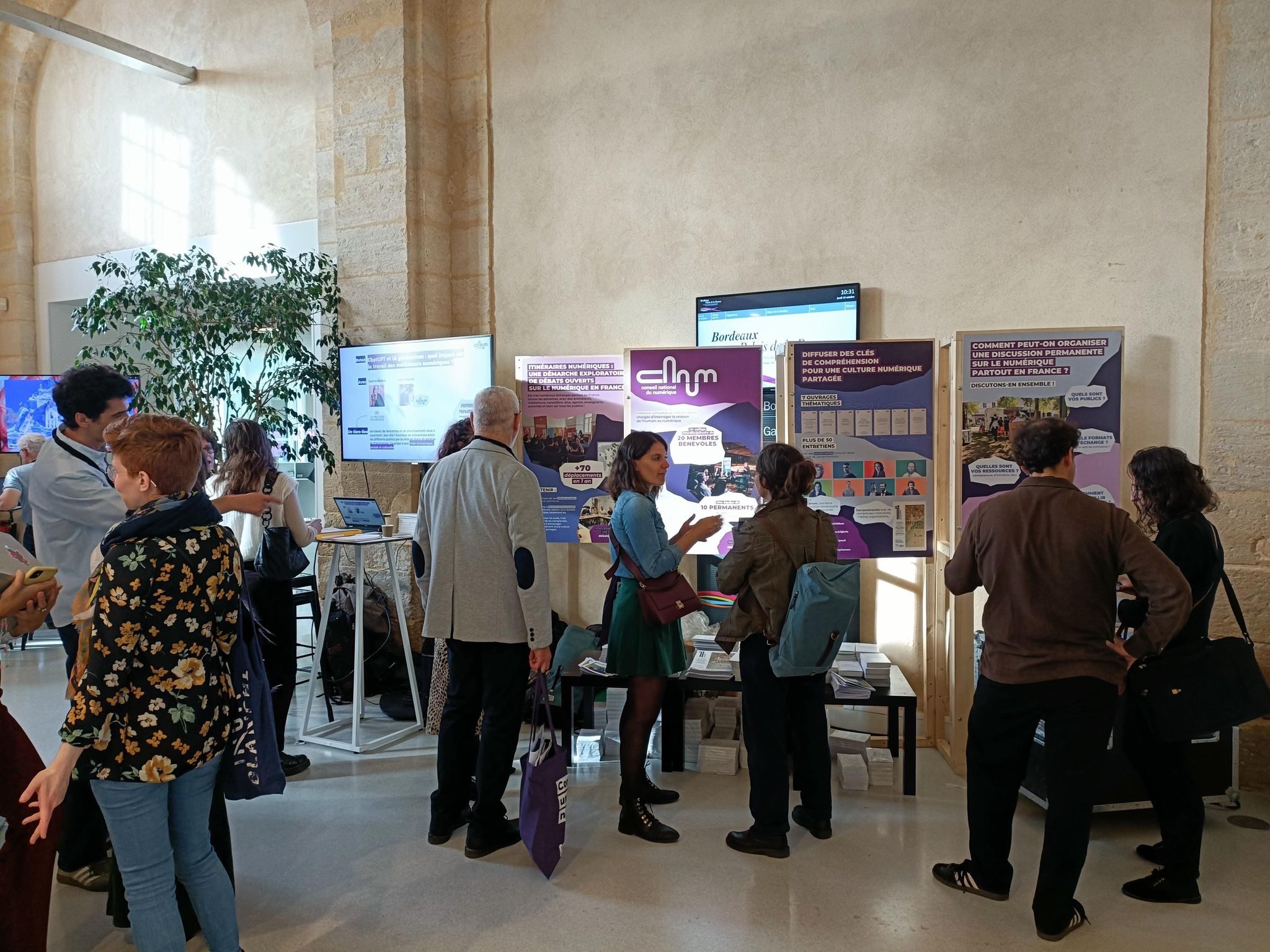 onNEC 2023 - photo de personnes échangeant devant le stand du Conseil national du numérique