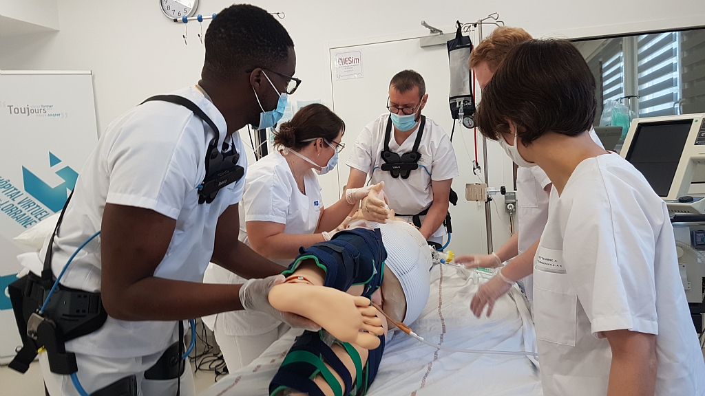 Des personnels soignants utilisent des exosquelettes pour retourner un mannequin de patient en réanimation.