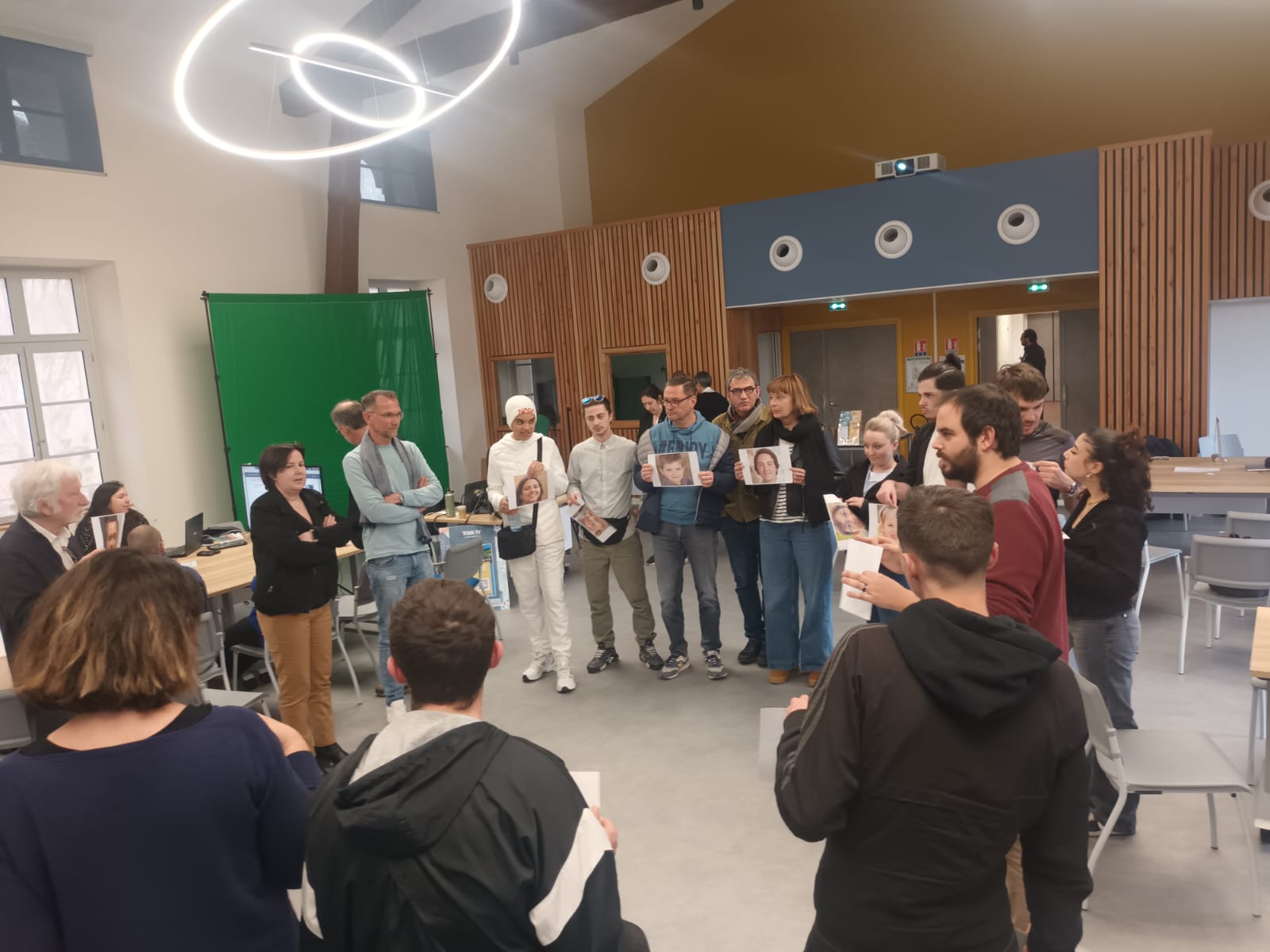  Visuel d'un atelier de médiation sur les IA génératives d'images où l'on voit les participants debouts en cercle avec une photo à la main.